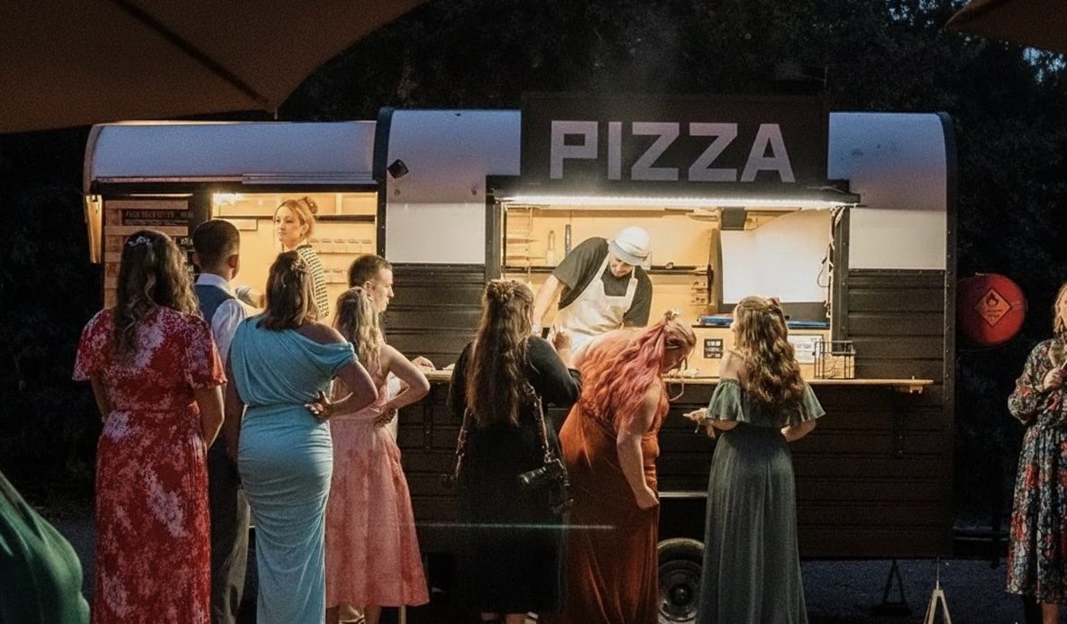 Gäste am Jonis Pizza-Trailer bei einer Abendveranstaltung